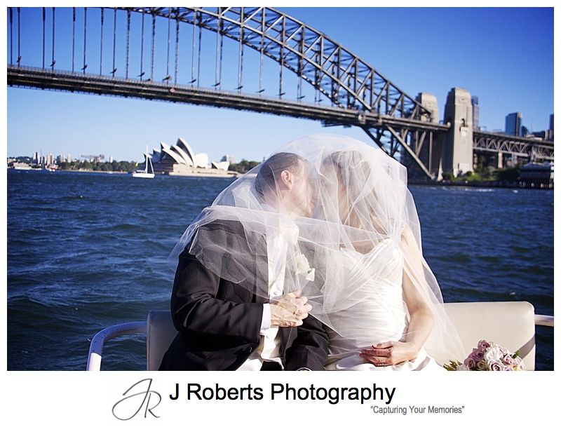 Couple kissing under a veil while riding a sydney water taxi - wedding photography sydney